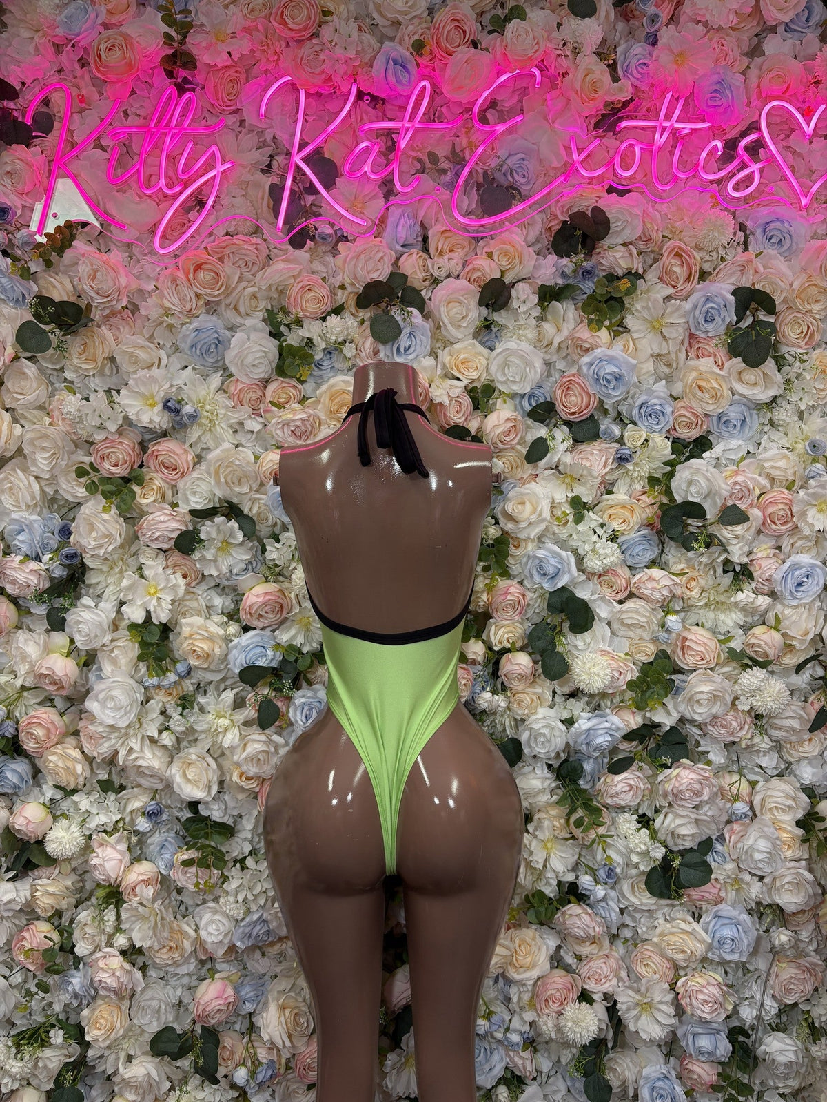Neon green one-piece swimsuit with black upper and side panels, high-cut leg