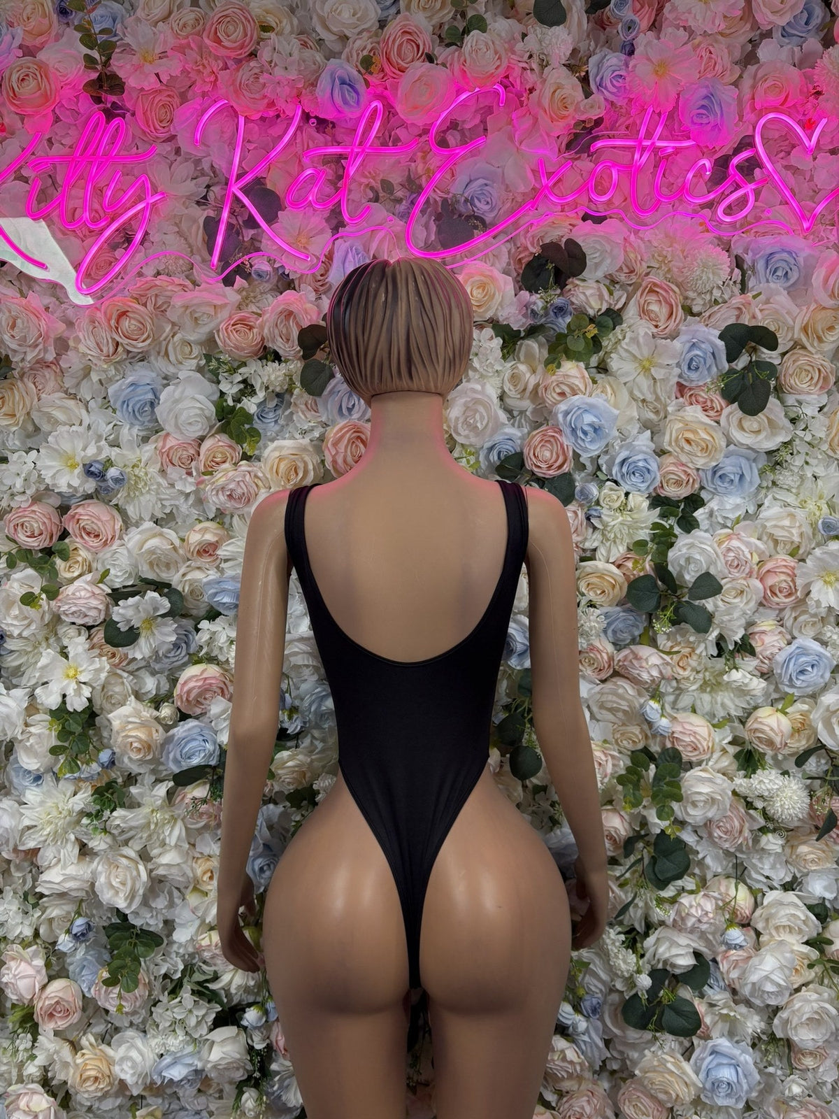 Black bodysuit with a low scoop back and high-cut legs, shown from behind