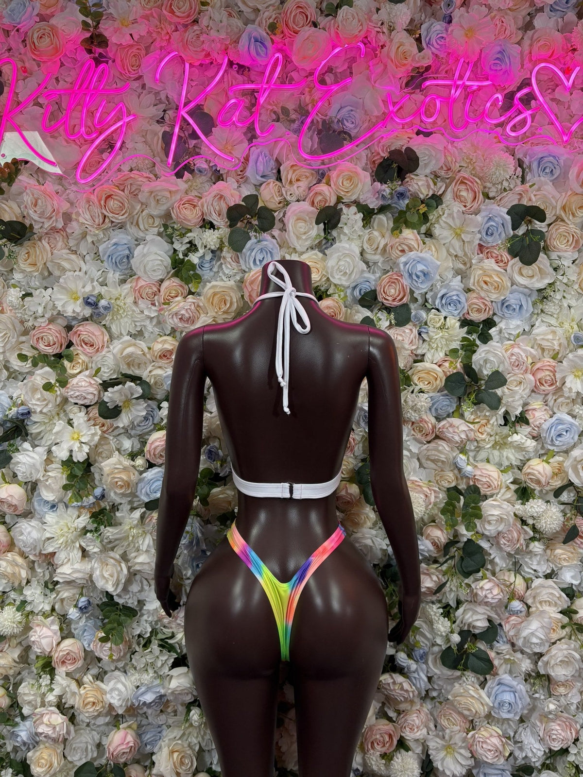Back of the rainbow multicolor halter bodysuit, showing white neck ties and a narrow thong bottom.