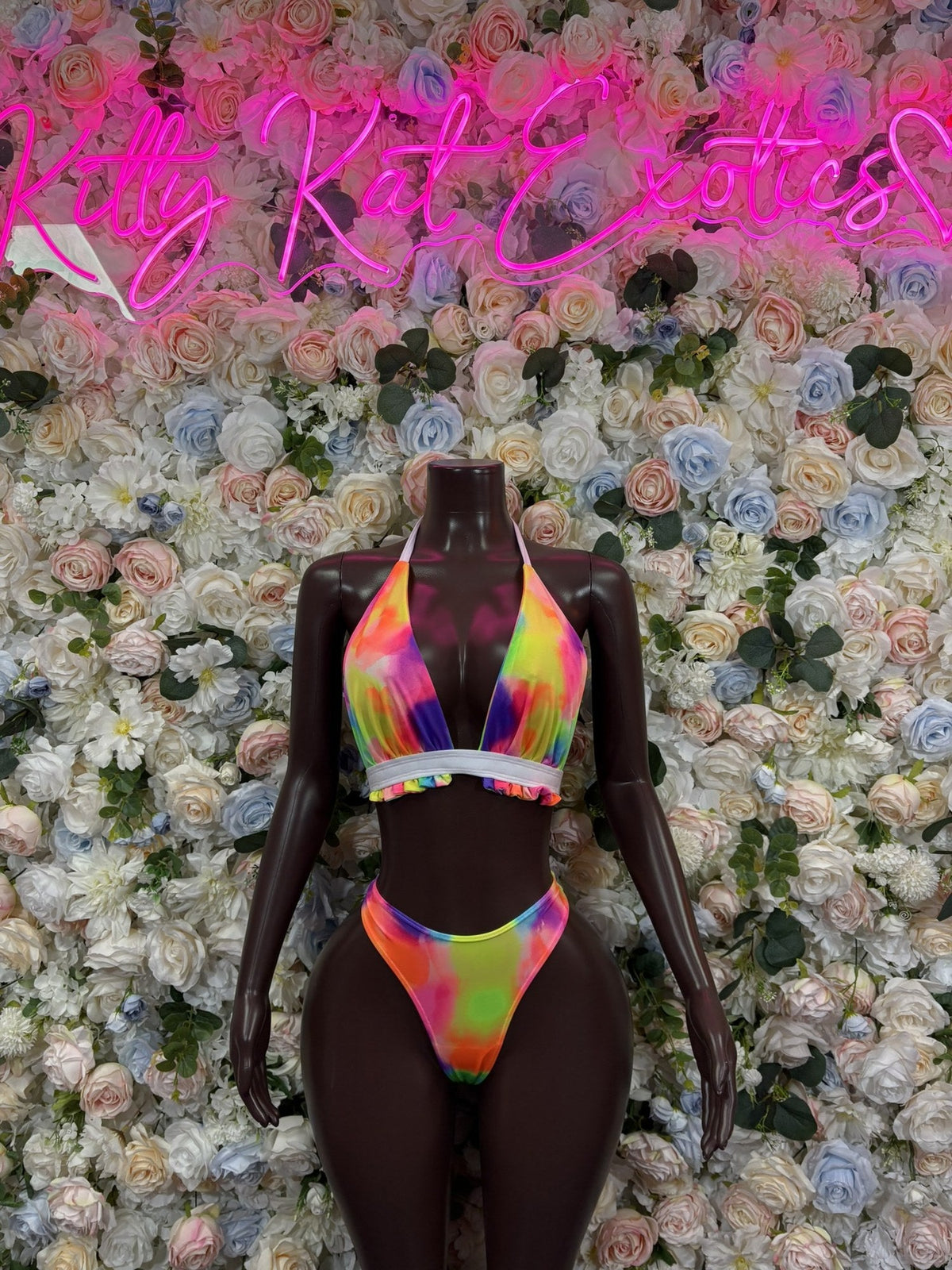 Rainbow multicolor halter cutout bodysuit on a mannequin, with a deep V neckline and high-cut bottom.