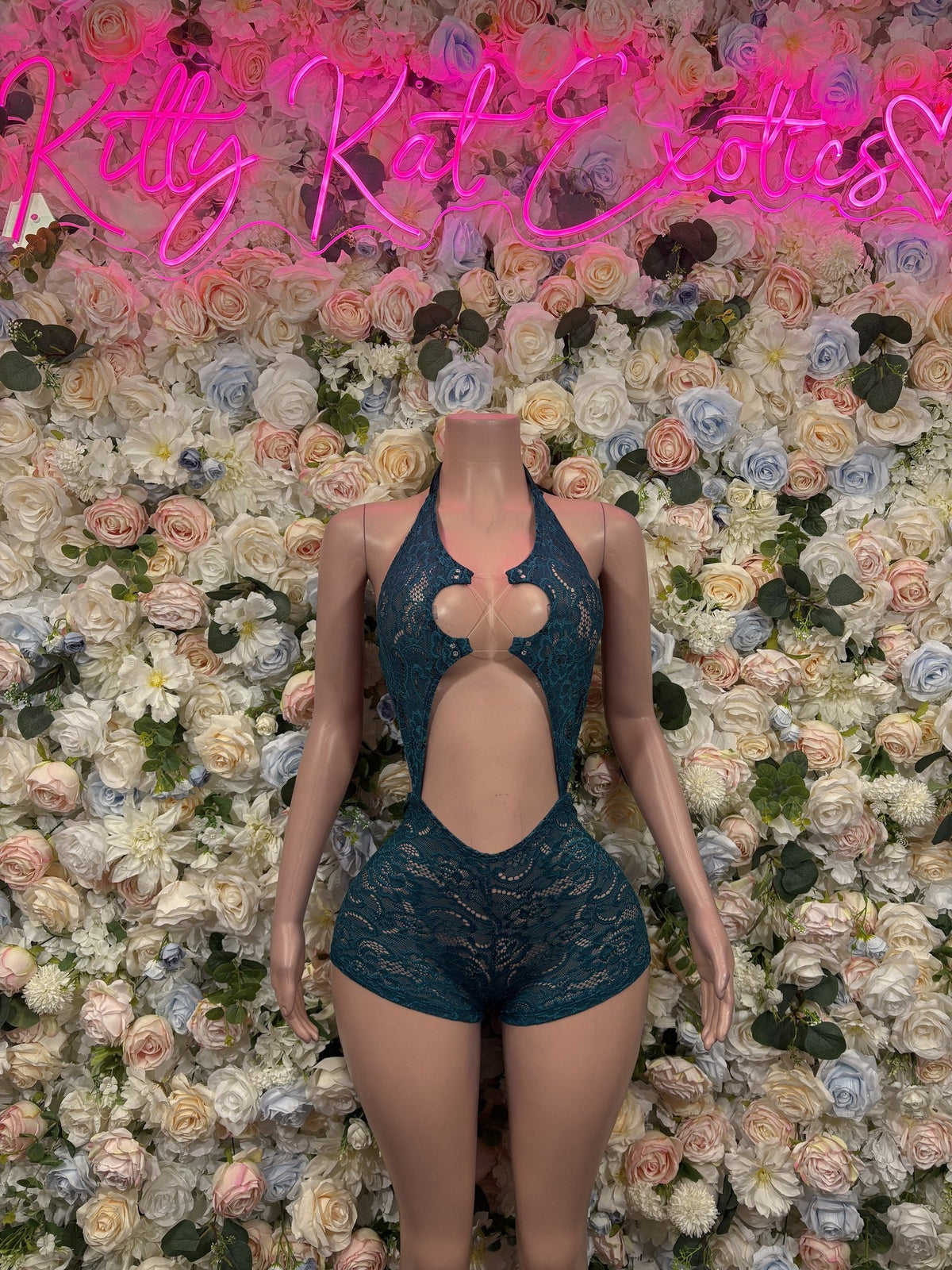 Teal lace romper with halter neckline, chest cutouts, a large front cutout, and shorts.
