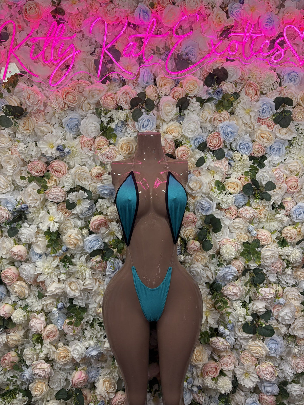 Turquoise high-neck cutout bodysuit with black trim and high-cut legs, shown from the front