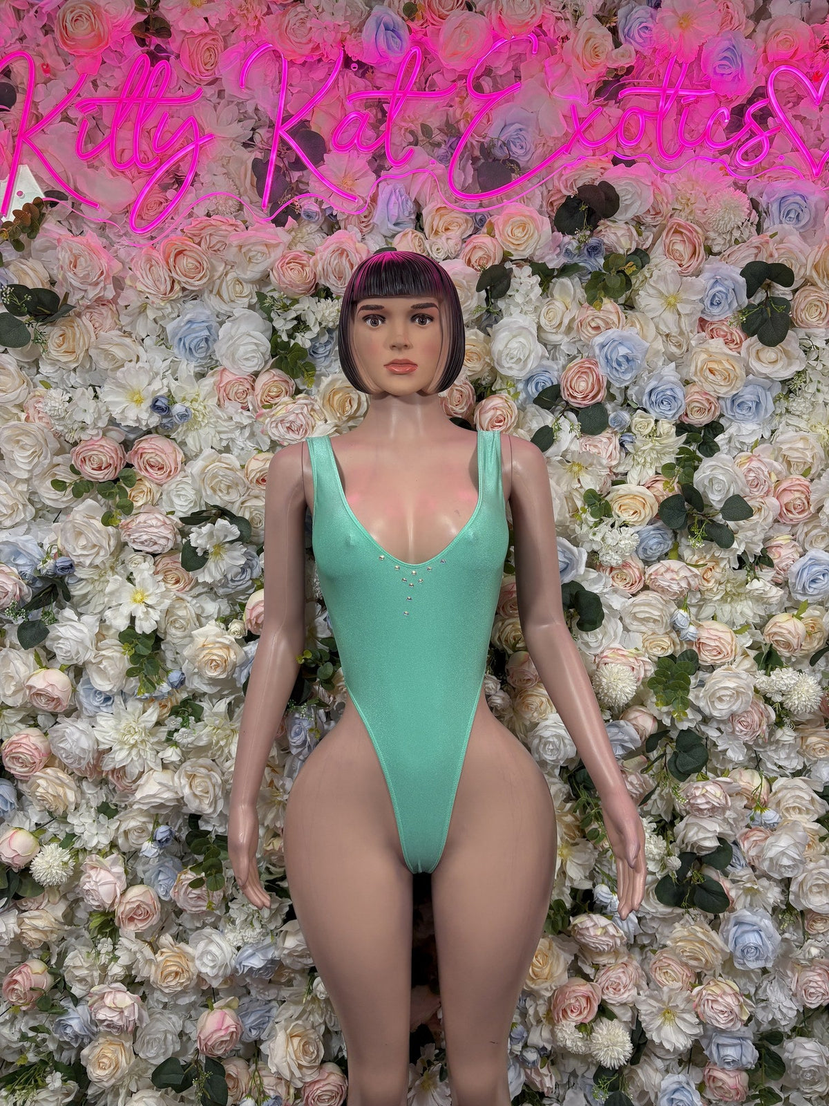 Mint green deep-V halter bodysuit with high-cut legs and small front embellishments