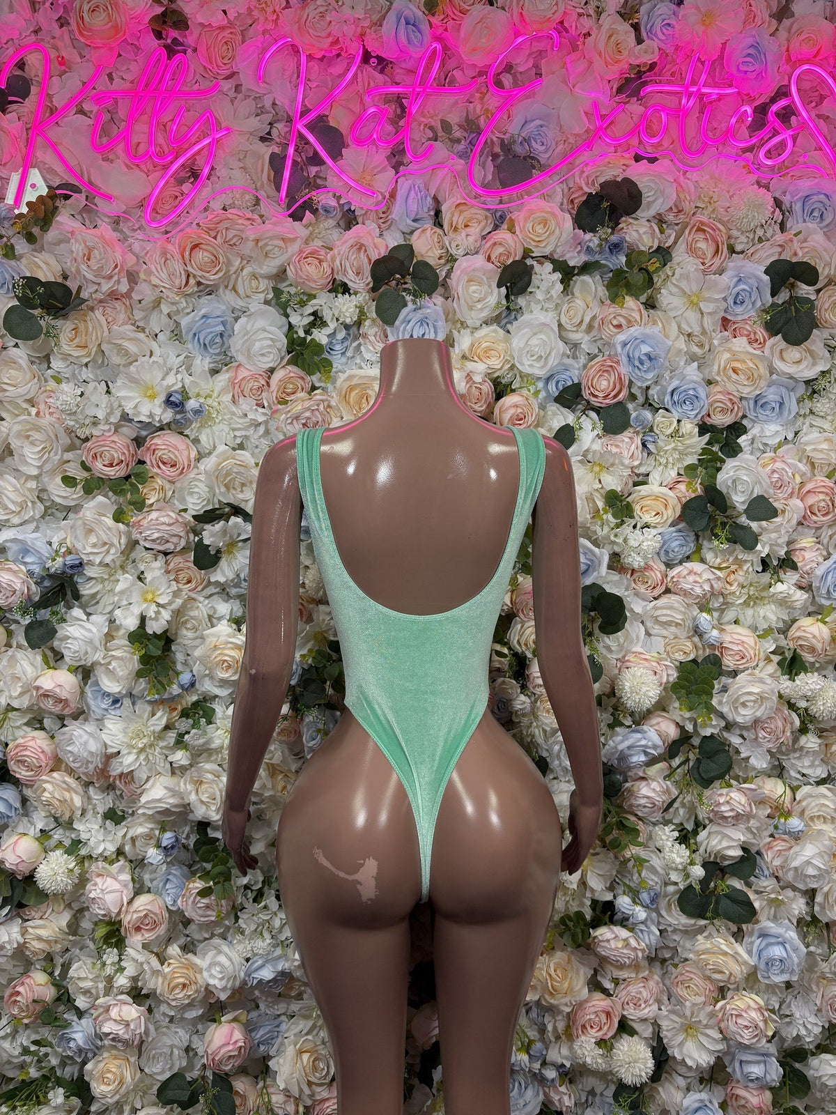 Mint green bodysuit back with a low scoop neckline and high-cut legs