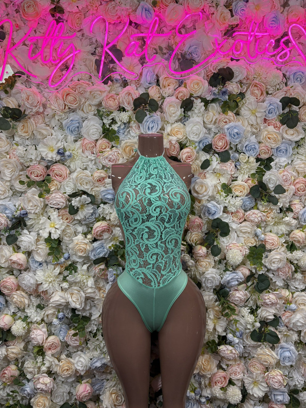 Mint green lace-front bodysuit with a high neckline and sheer floral lace panels.