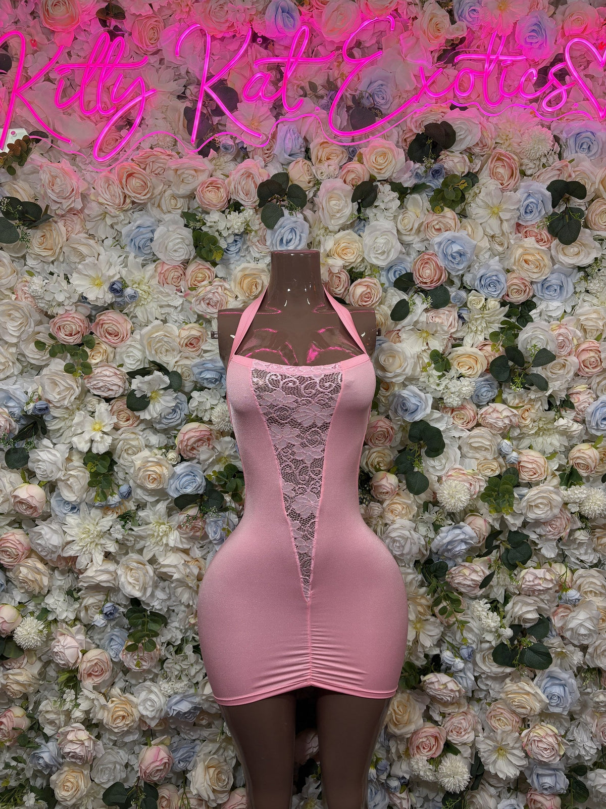 Pink fitted mini dress with vertical lace panel, sleeveless, V-front neckline on mannequin