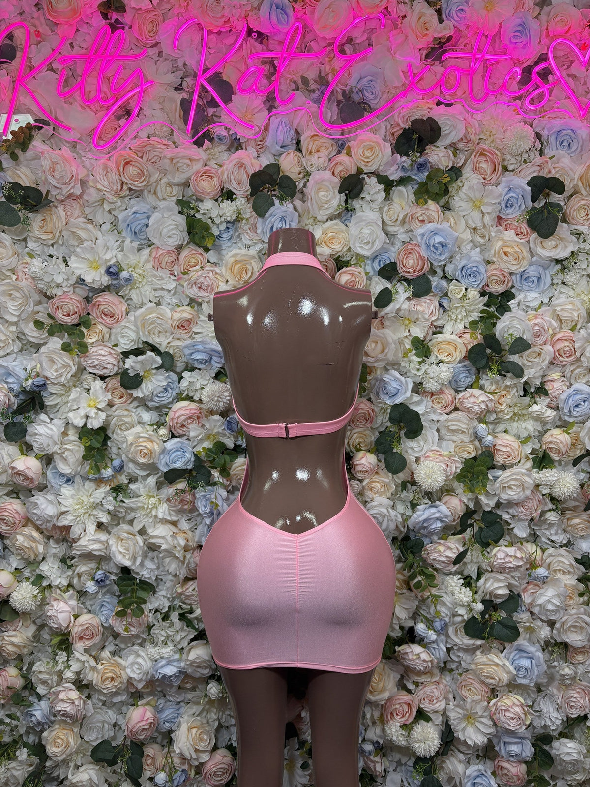 Pink fitted mini dress back view on mannequin, vertical lace detail, sleeveless racerback