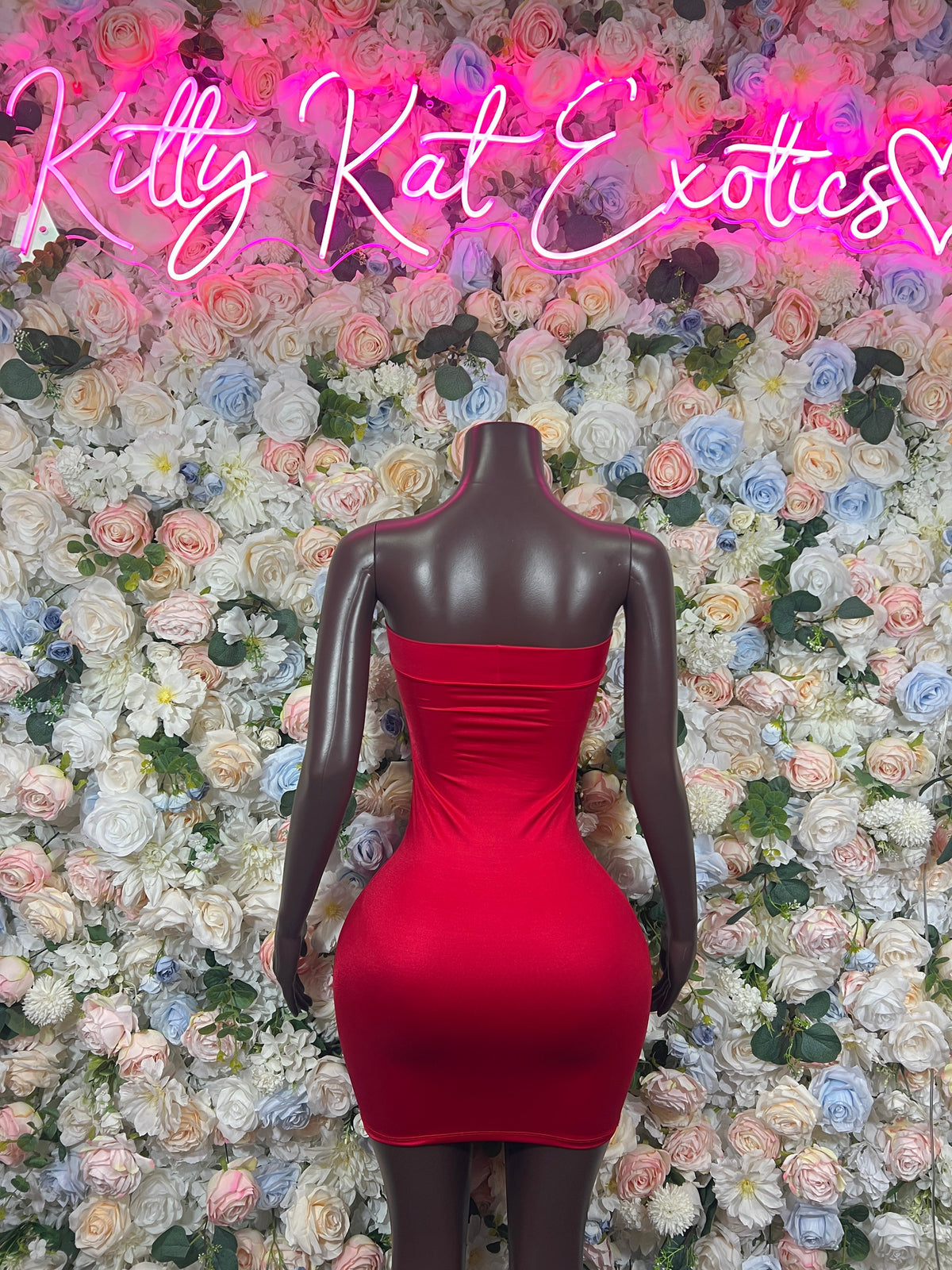 Red halter mini dress on mannequin, ruched bodice