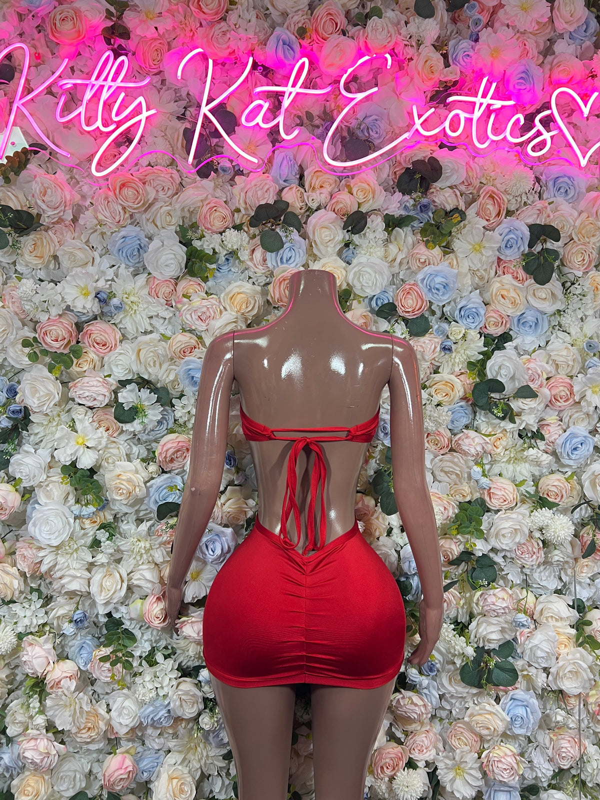 Red strapless mini dress with rhinestone cutout and ribbon-tie back, angled view