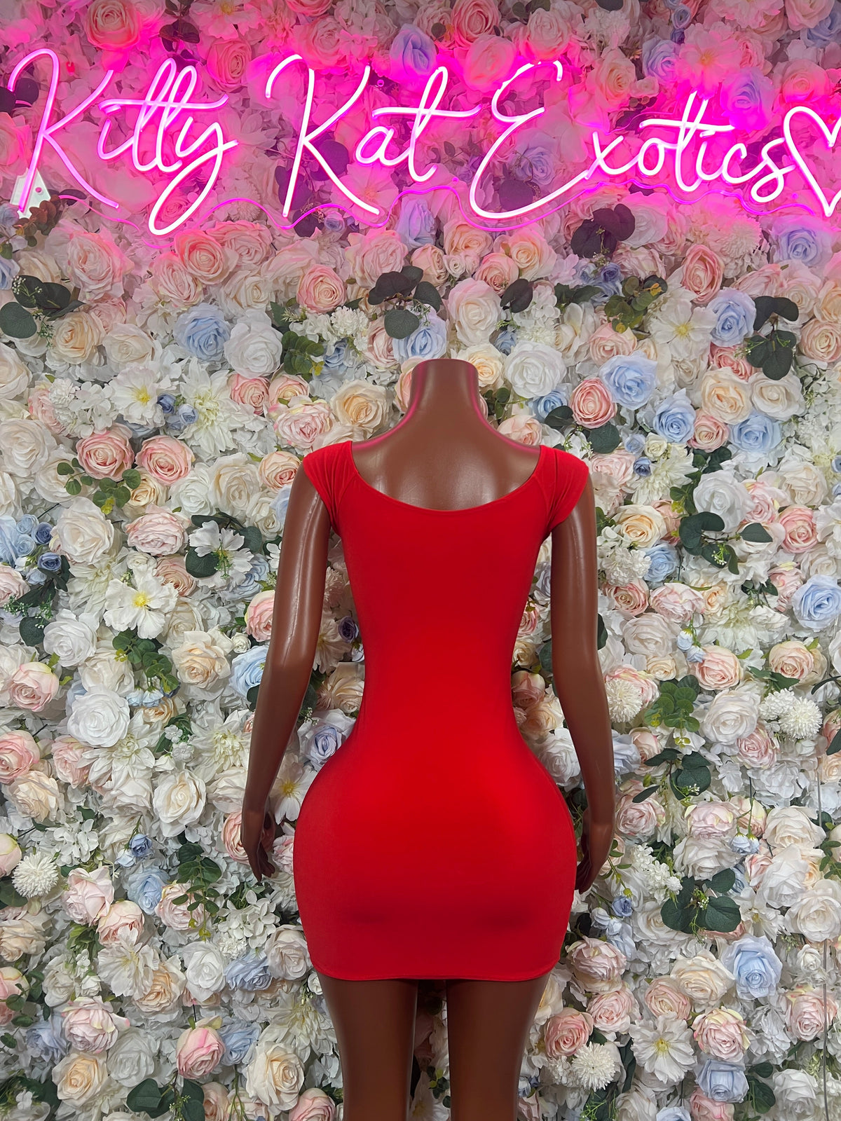 Red strappy mini dress with side cutouts and scoop neckline on a mannequin