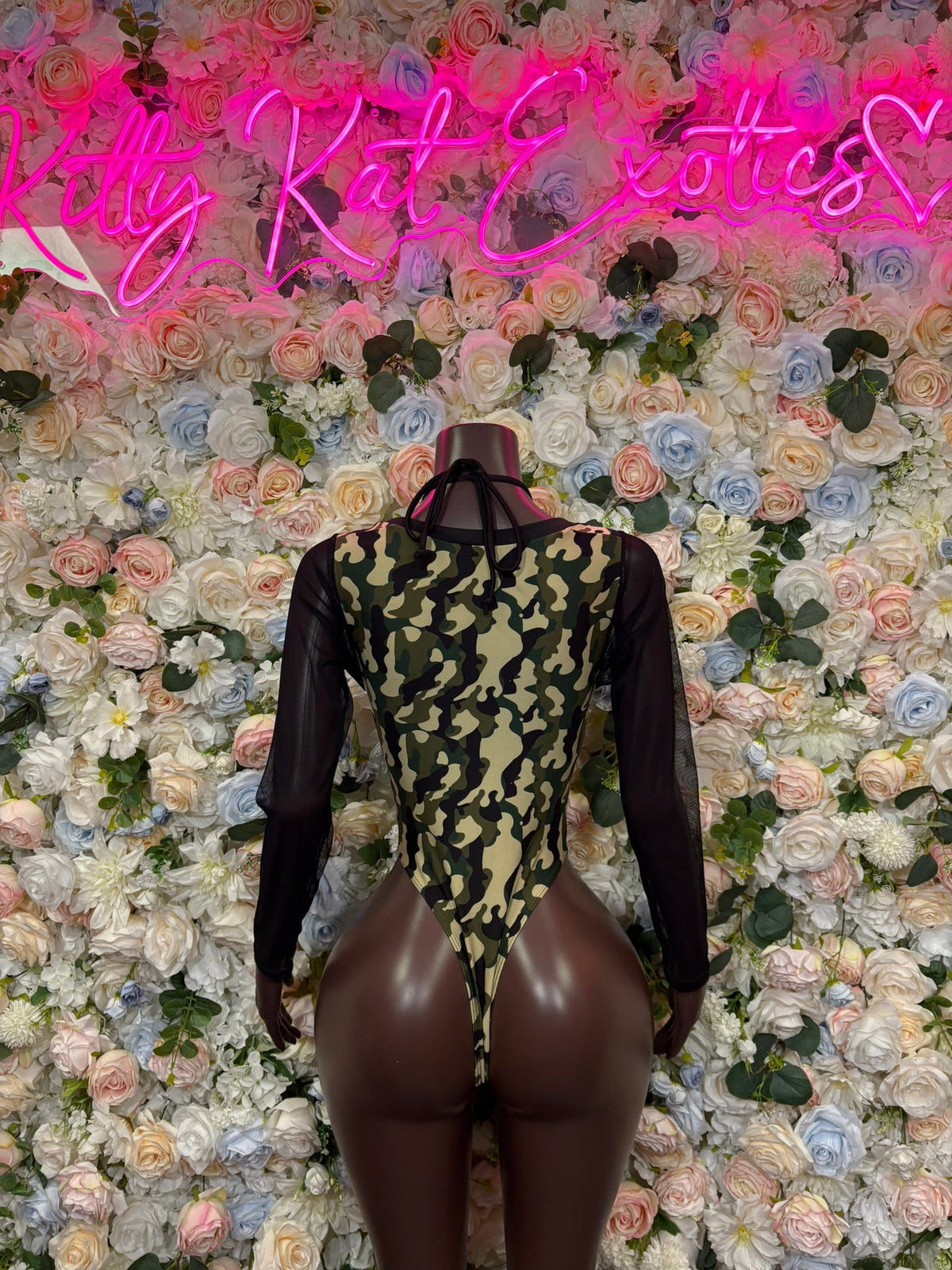 Full-length camo cutout bodysuit with sheer black sleeves and lace-up front, high-leg
