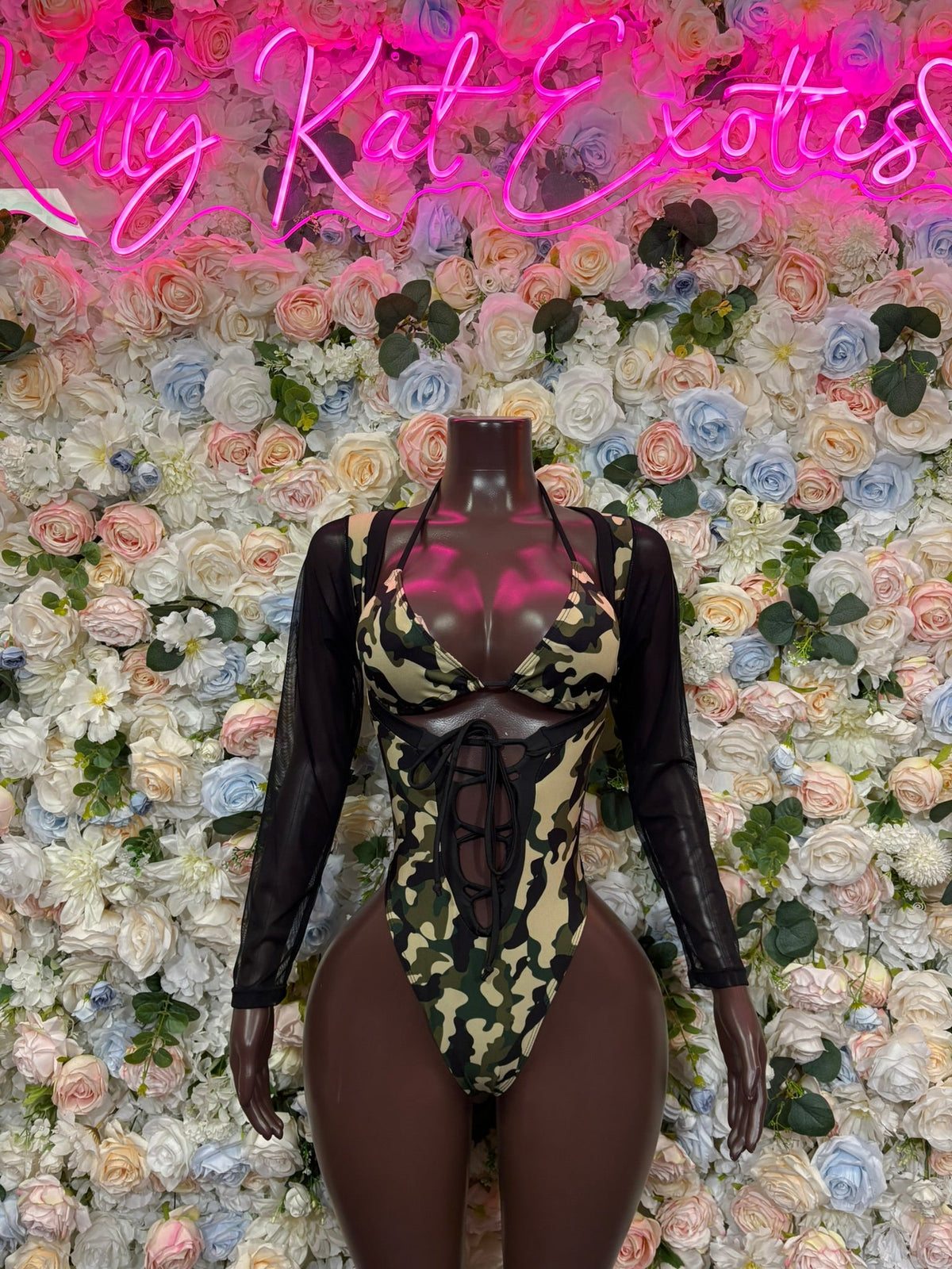 Camo cutout bodysuit with sheer black sleeves, lace-up neckline, high-leg fit