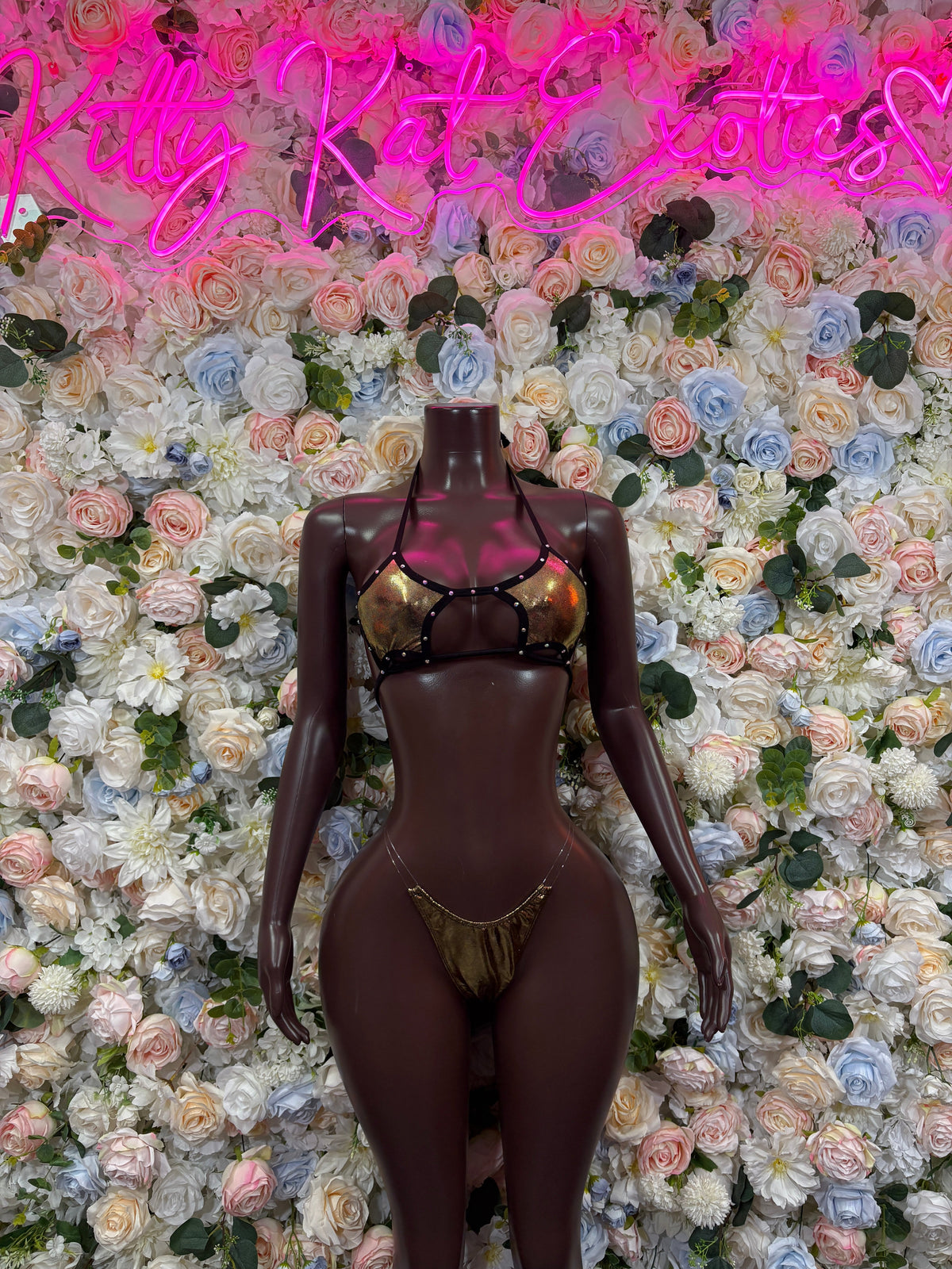 Dark bodysuit with metallic gold harness straps and front cutouts, thong style