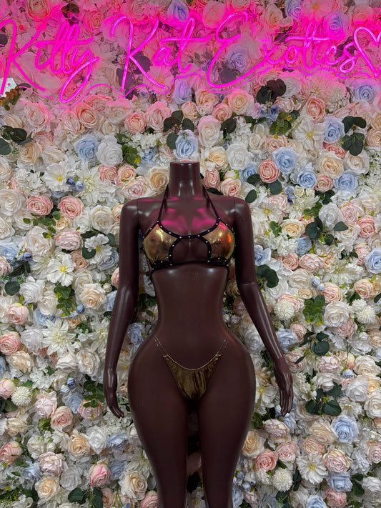 Dark bodysuit with metallic gold harness straps and front cutouts, thong style