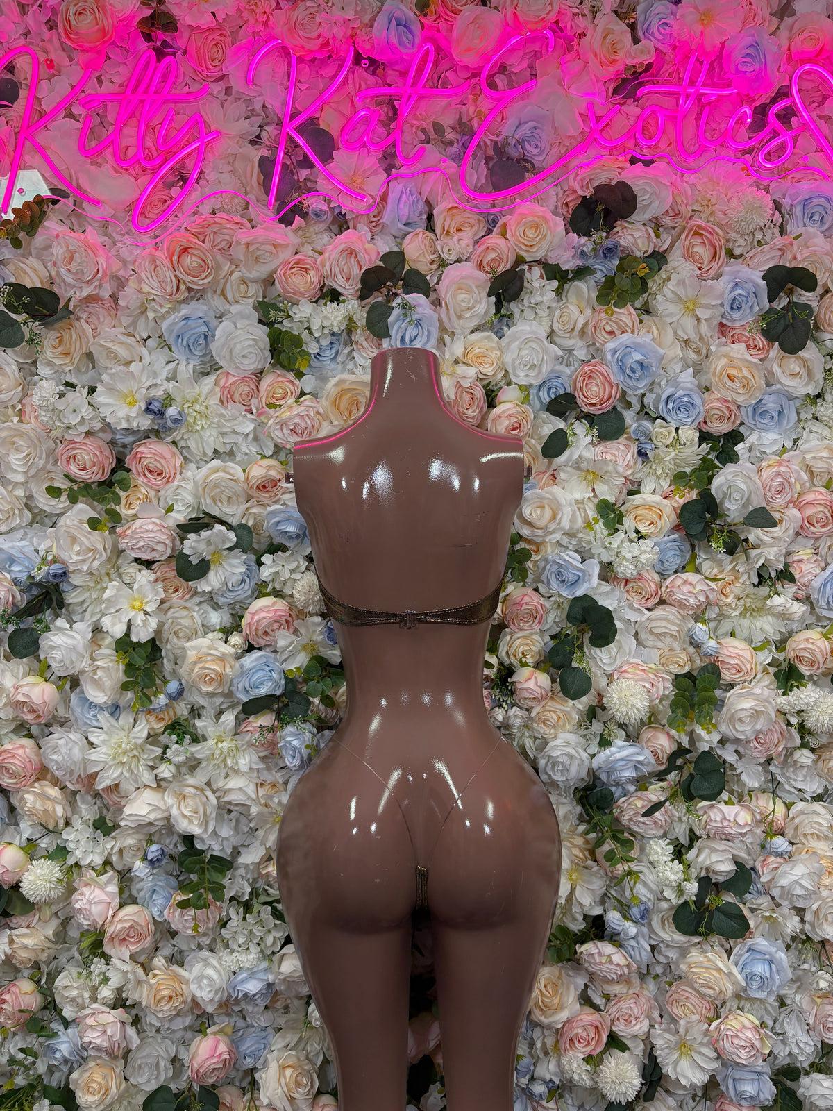 Metallic gold strapless bodysuit with black trim, on a mannequin