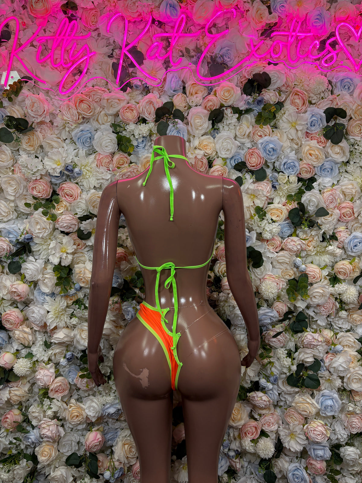 Orange ring-cutout bikini set with neon green trim, back view on mannequin