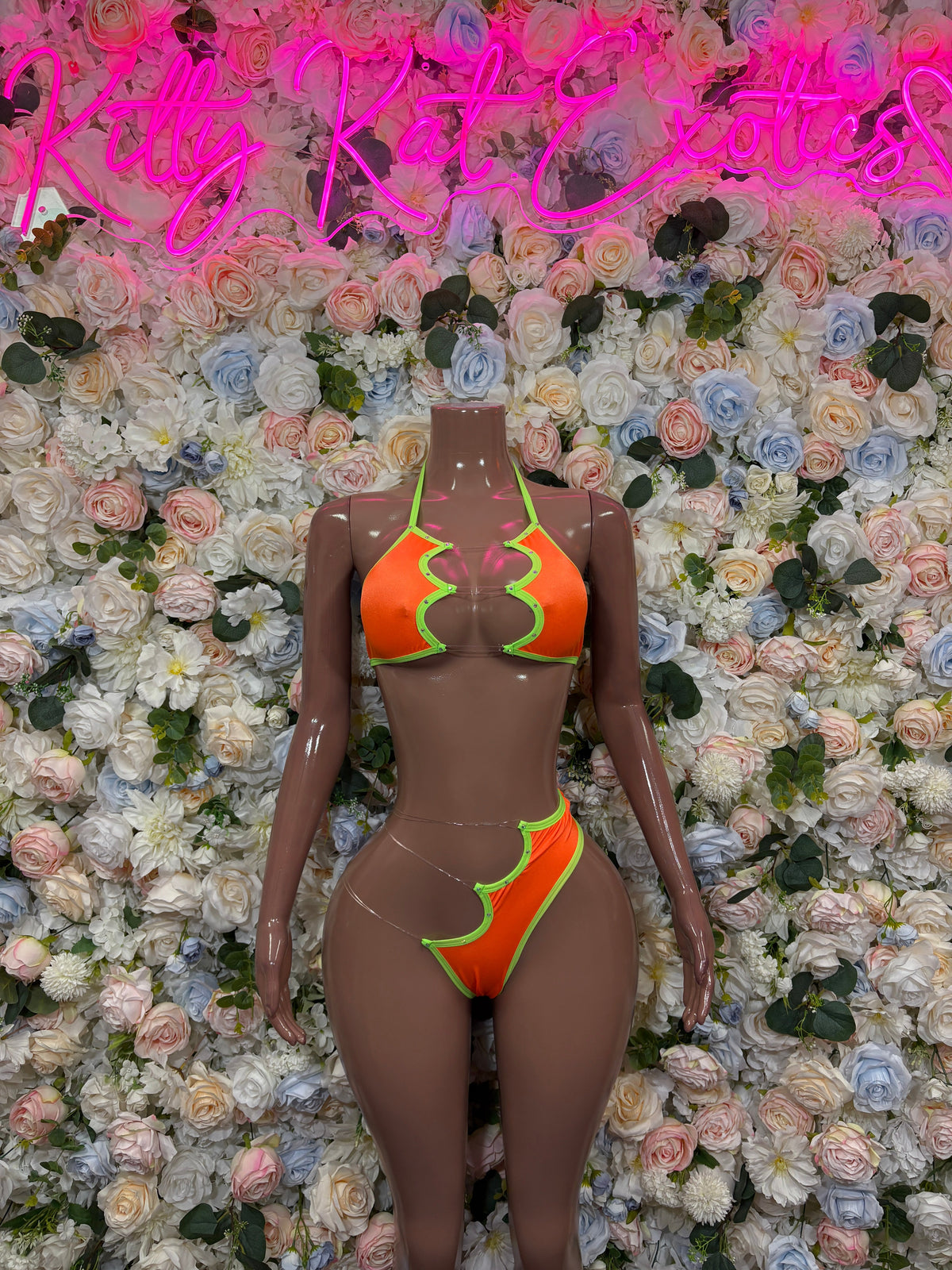Orange ring-cutout bikini set with neon green trim, front view on single mannequin